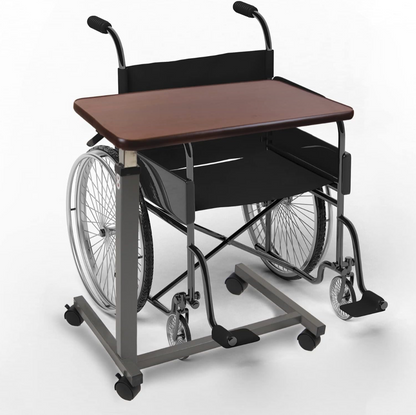 A compact wheelchair with an attached adjustable desk. The wheelchair features a gray tubular metal frame, black fabric seat and backrest, silver spoked wheels, and black casters.